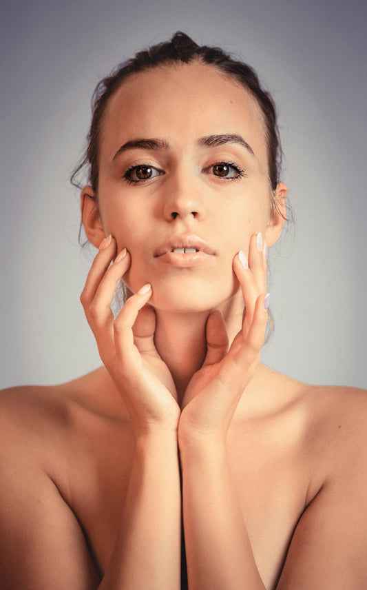 A woman posing with her hands on her face